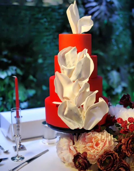 Traditionelle mehrschichtige Hochzeitstorte. schöne köstliche rote süße Dessert mit weißen Blumen dekoriert — Stockfoto