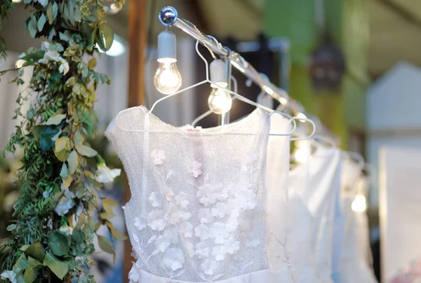 Peu d'élégantes robes de mariée, de demoiselle d'honneur, de soirée, de bal ou de bal sur un cintre dans un magasin de mariage . — Photo