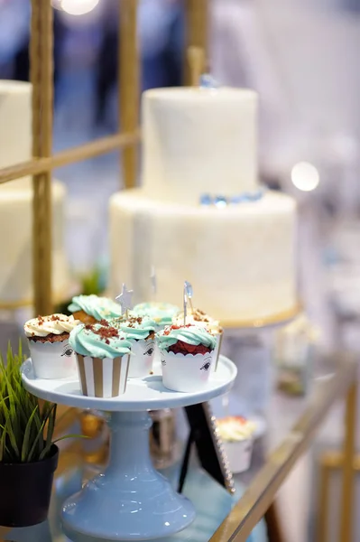 Deliciosos cupcakes de casamento coloridos com flor e estrelas e belo bolo envidraçado. Mesa doce elegante . — Fotografia de Stock