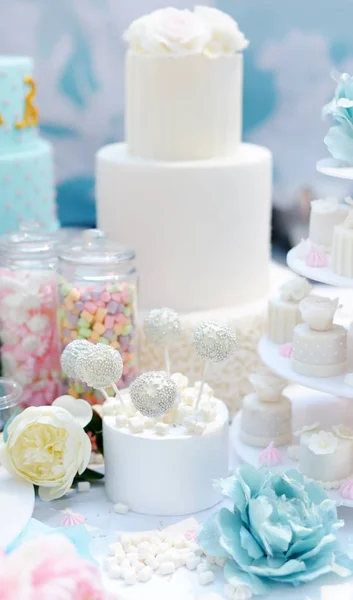 Aniversário tradicional / bolo multi-camada de casamento decorado com flores. E bela sobremesa doce deliciosa - cupcakes, marshmallow, pops de bolo de baunilha. Mesa doce elegante . — Fotografia de Stock