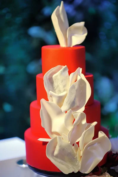 Traditionelle mehrschichtige Hochzeitstorte. schöne köstliche rote süße Dessert mit weißen Blumen dekoriert — Stockfoto