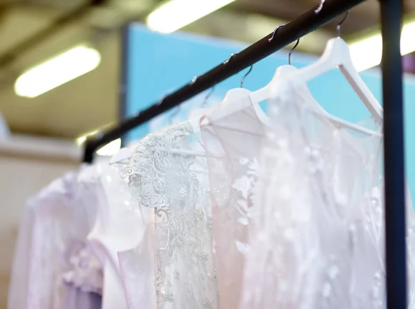 Birkaç zarif düğün, nedime, akşam, balo elbisesi veya balo elbiseleri bir gelinlik dükkanında bir askı üzerinde. — Stok fotoğraf