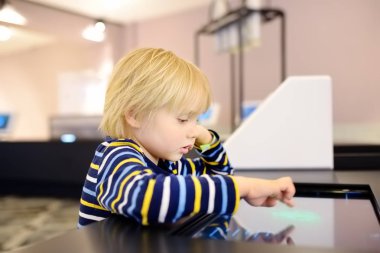 Küçük beyaz çocuk bilimsel bir müzede sergi arıyor.