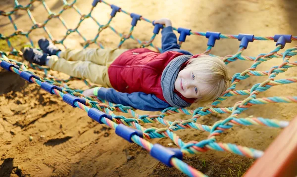 Sevimli küçük sarışın kafkas çocuk açık oyun alanında eğleniyor. Çocuklar için aktif spor eğlence. Hamak taki çocuk — Stok fotoğraf