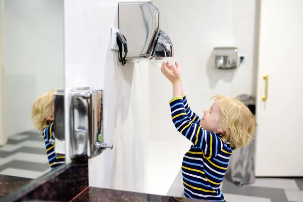 トイレで手を乾かす小さな白人の少年 — ストック写真