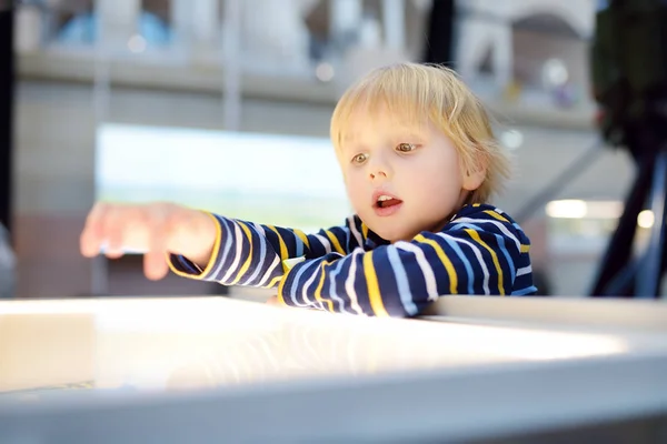 Little? aucasian chłopiec szuka ekspozycji w Muzeum naukowym — Zdjęcie stockowe