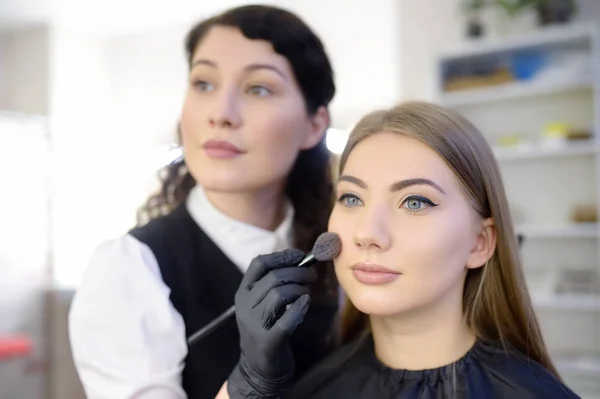 Make-up-Artist Anwendung der Ton der Stiftung mit speziellen Pinsel auf Gesicht junge schöne Modell. Gesichtspflege und Make-up — Stockfoto