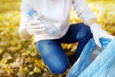 Gönüllü plastik çöp toplayıp açık havada biyobozunur çöp torbasına koyarak.