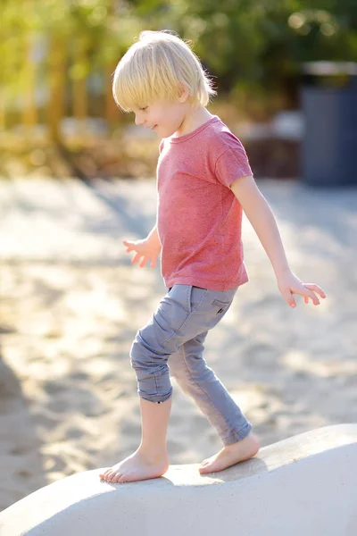 Petit garçon s'amusant sur l'aire de jeux extérieure du parc public à la journée ensoleillée d'été . — Photo
