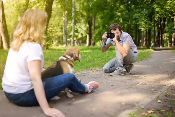 Young man take a shot beautiful woman with dog in sunny summer park. Date or walking. — Stock Photo, Image