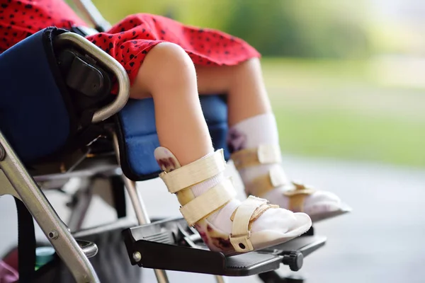 坐在轮椅上的残疾女孩。在她的腿上矫形器。儿童脑瘫。包含. — 图库照片