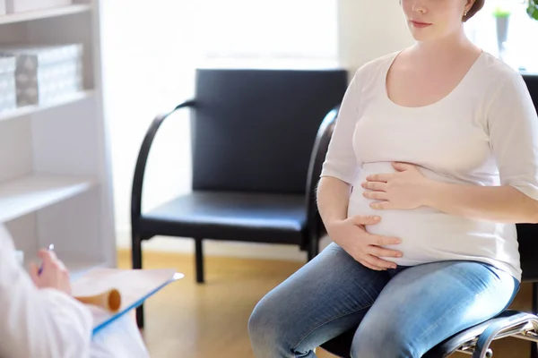 Ginecólogo médico acepta de una mujer embarazada y ayuda a hacer un plan de nacimiento. Seguro médico de maternidad. Médico de familia para la gestación. Permiso de maternidad . — Foto de Stock