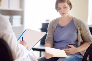 Kadın doğum uzmanı jinekolog doktor hamile bir kadını kabul eder ve bir doğum planı yapmaya yardımcı olur. Sağlık sigortası çocuk doğurma. Doğum izni.