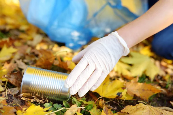 Sukarelawan mengambil sampah logam dan memasukkannya ke dalam kantong sampah biodegradable di luar ruangan . — Stok Foto