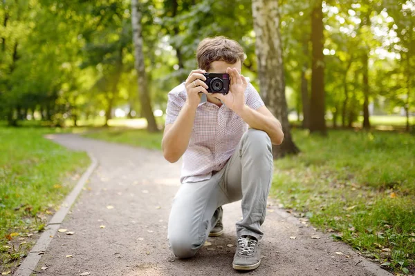 Jonge man nemen een schot in het zonnige zomerpark. — Stockfoto