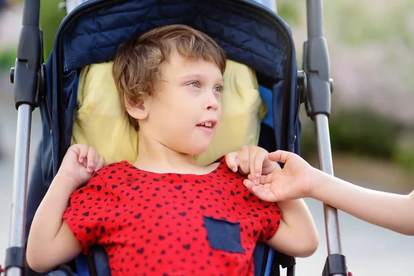 Comunicação de menino e uma menina deficiente em uma cadeira de rodas andando no verão Parque. Inclusão. Paralisia cerebral infantil . — Fotografia de Stock