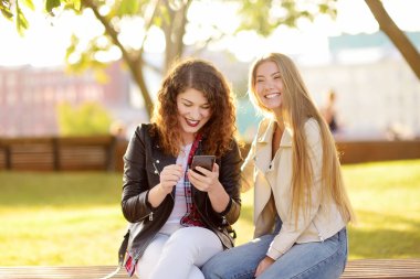 Açık havada iki güzel genç kadın portresi. Kadın güzelliğinin çeşitli. Güneşli bir gün içinde birlikte iki beyaz kız arkadaş yürüyüş