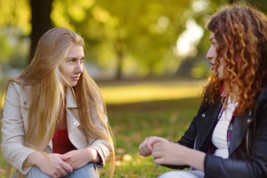 Açık havada iki güzel genç kadın portresi. Kadın güzelliğinin çeşitli. Güneşli bir gün içinde birlikte iki beyaz kız arkadaş yürüyüş