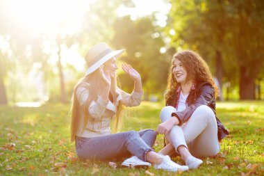 Açık havada iki güzel genç kadın portresi. Kadın güzelliğinin çeşitli. Güneşli bir gün içinde birlikte iki beyaz kız arkadaş yürüyüş
