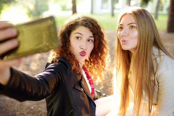 Two beautiful young women take selfie on sunny park. Girlfriends. — Stock Photo, Image