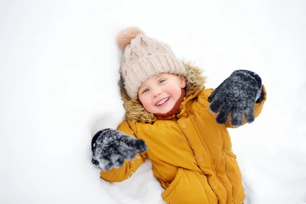 Mały chłopiec bawiący się w śniegu — Zdjęcie stockowe