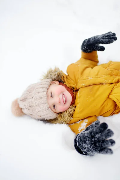 Küçük çocuk karda eğleniyor. — Stok fotoğraf