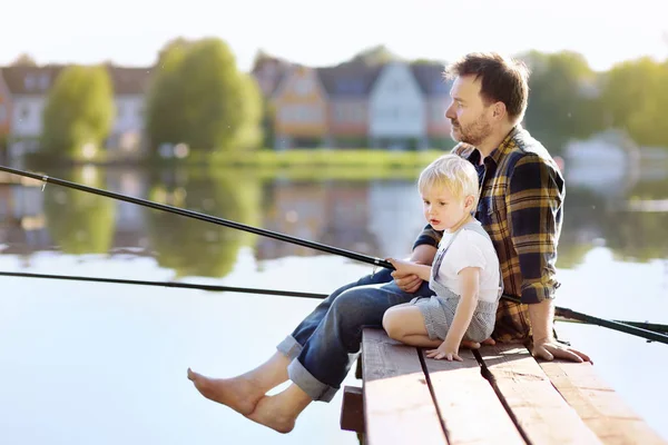 Gammal pappa och liten son fiske på sjön eller floden i helgen. Utomhusaktiviteter sommaraktiviteter för barn familj. — Stockfoto