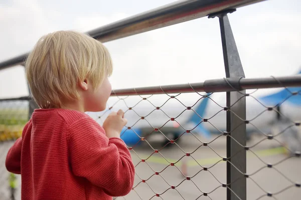 Uçuş öncesinde küçük Avrupa kentinin havaalanında gözlem güvertesinde uçaklara sevimli küçük çocuk bakmak. Çekici çocuk yolcu yatılı bekliyor. Çocuk konsepti ile aile seyahati — Stok fotoğraf
