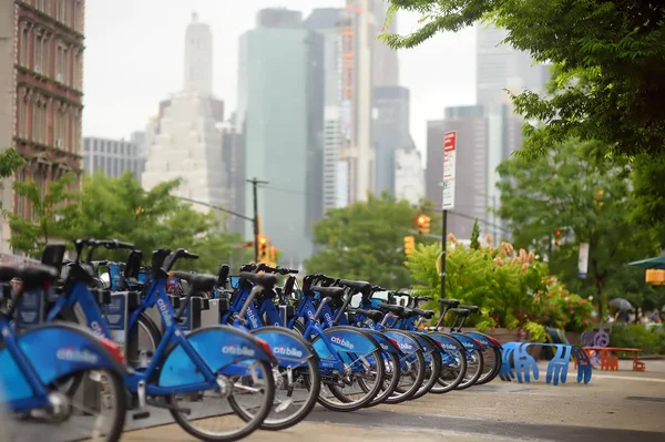 New York, Verenigde Staten-11 juli 2019: uitzicht op de parkeerplaats van City rent fietsen en de wolkenkrabbers van Manhattan. — Stockfoto