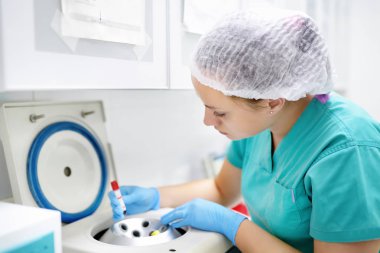 Laboratuvardaki kadın santrifüj tüpüne kan koyar. Genel kan testleri, biyokimya testleri ve eser elementler.