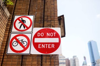 New York'ta caddenin tuğla duvarında engelleyici trafik işareti. İnsanlar ve bisiklet için giriş yok.