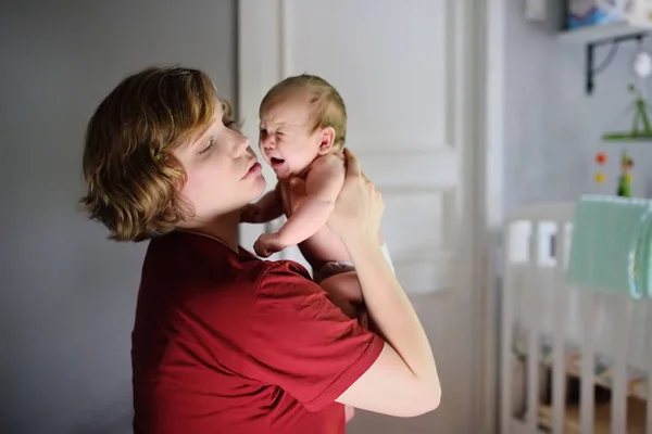 Mladá matka s pláčem novorozenců doma. Dětský pláč během Kolic — Stock fotografie