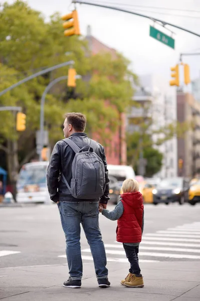 Kisfiú az apja úgy néz ki, a jel a közlekedési lámpa kereszteződésénél New York City, USA. Közlekedési törvények. — Stock Fotó