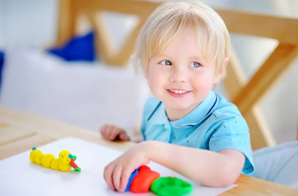 Chico creativo jugando con arcilla de modelado de colores en el jardín de infantes — Foto de Stock
