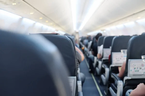 Vista de los aviones comerciales del salón. Despegue o aterrizaje. Filas de asiento con pasajeros . — Foto de Stock