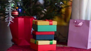 Işıklarla süslenmiş Yeni Yıl ağacının yanında duran Noel hediyeleri yığını. Evde tatil sabahı