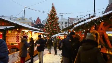 Tallinn, Estonya - 5 Ocak 2019: Karlı bir günde geleneksel sokak Noel pazarı. İnsanlar belediye meydanında rahat mevsimlik Avrupa festivali ile dolaşmak