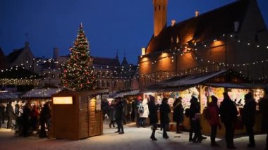 Tallinn, Estonya - 5 Ocak 2019: Karlı bir günde geleneksel sokak Noel pazarı. İnsanlar belediye meydanında rahat mevsimlik Avrupa festivali ile dolaşmak