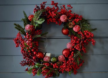Gri ahşap bir duvarın arkasında Noel çelengi