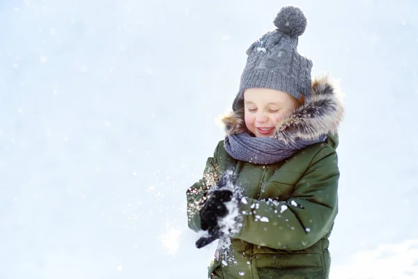 小さな男の子は雪と遊ぶのが楽しい。冬の子供たちとのアクティブな屋外レジャー. — ストック写真