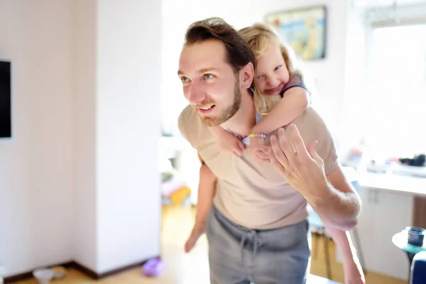 Щасливий молодий красивий батько зі своєю маленькою кучерявим волоссям дочка грає вдома . — стокове фото