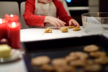 Mutlu küçük çocuk tatil sezonunda kurabiye pişirir. Çocuklarla Noel ve Yeni Yıl.