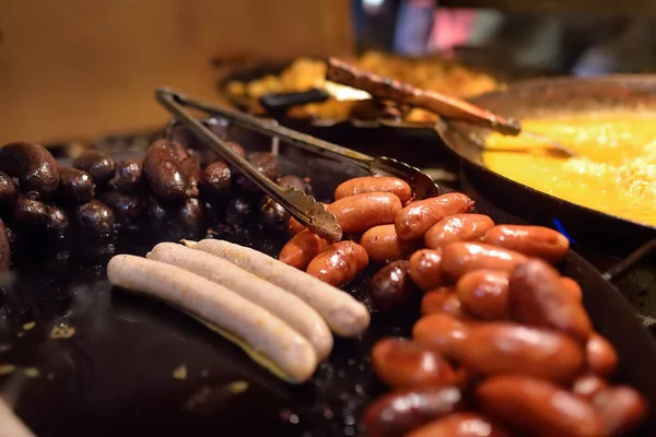 Warm eten op de kerstmarkt van Tallinn. Worstjes en kupaty kookt op een open vuur. — Stockfoto