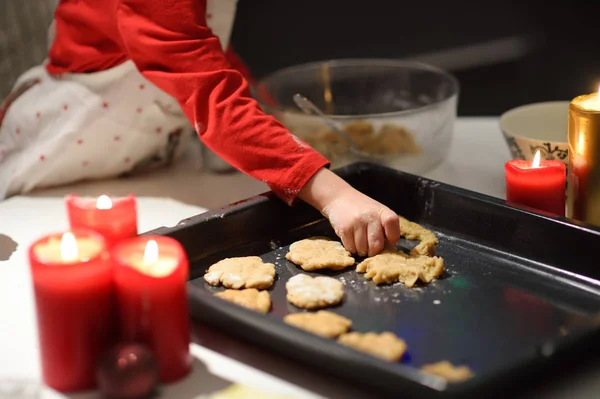 Vrolijk jongetje bakt koekjes tijdens de feestdagen. Kerstmis en Nieuwjaar met kinderen. — Stockfoto