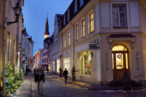 Tallinn, Estonia - 6 January 2019: people on street of old town of Tallinn in winter evening.