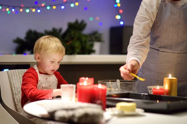 Merry little boy and his young grandmother bake cookies together during the holidays season. Christmas and New Year with kids. — Stock Photo, Image