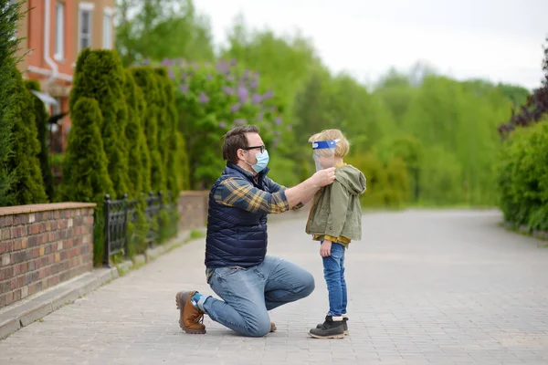 Mann Mit Gesichtsmaske Legt Gesichtsschutz Auf Kind Auf Straße Oder — Stockfoto