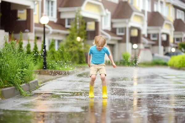 Kleine Jongen Met Gele Rubberen Laarzen Springend Een Plas Water — Stockfoto