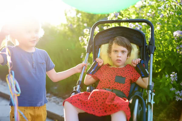 公園の夏を歩く車椅子の男の子と障害のある女の子のコミュニケーション 子供の脳性麻痺 障害児の家族 — ストック写真