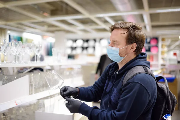 中年男子戴着防护面罩 在商店里挑选陶器 社会距离限制和面罩 在大肠病毒大流行的情况下衡量安全性 — 图库照片